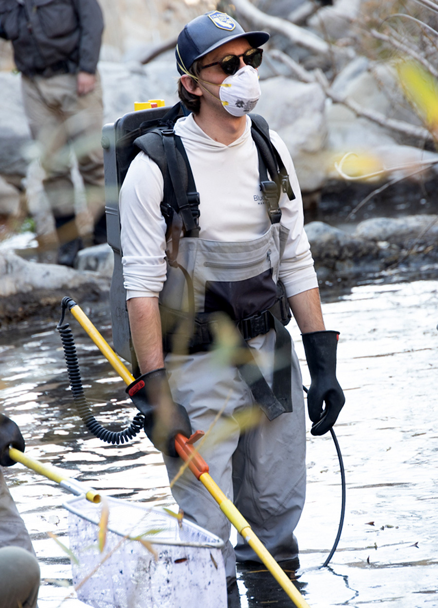 A fisheries biologist with an electro-shock backpack.