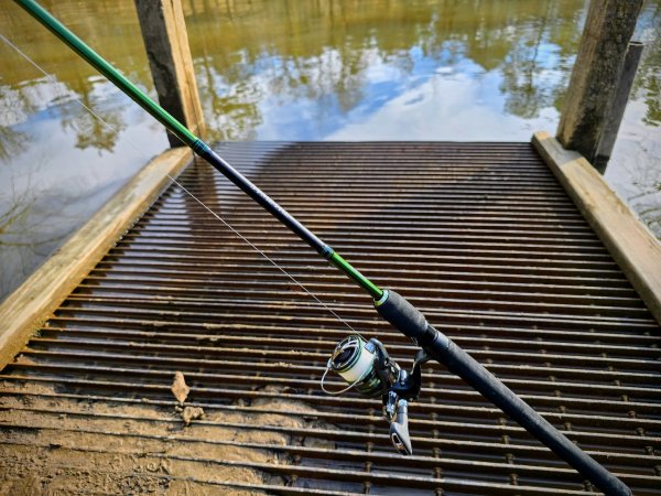  The Shimano Symetre spinning rod and reel combo with water in the background.