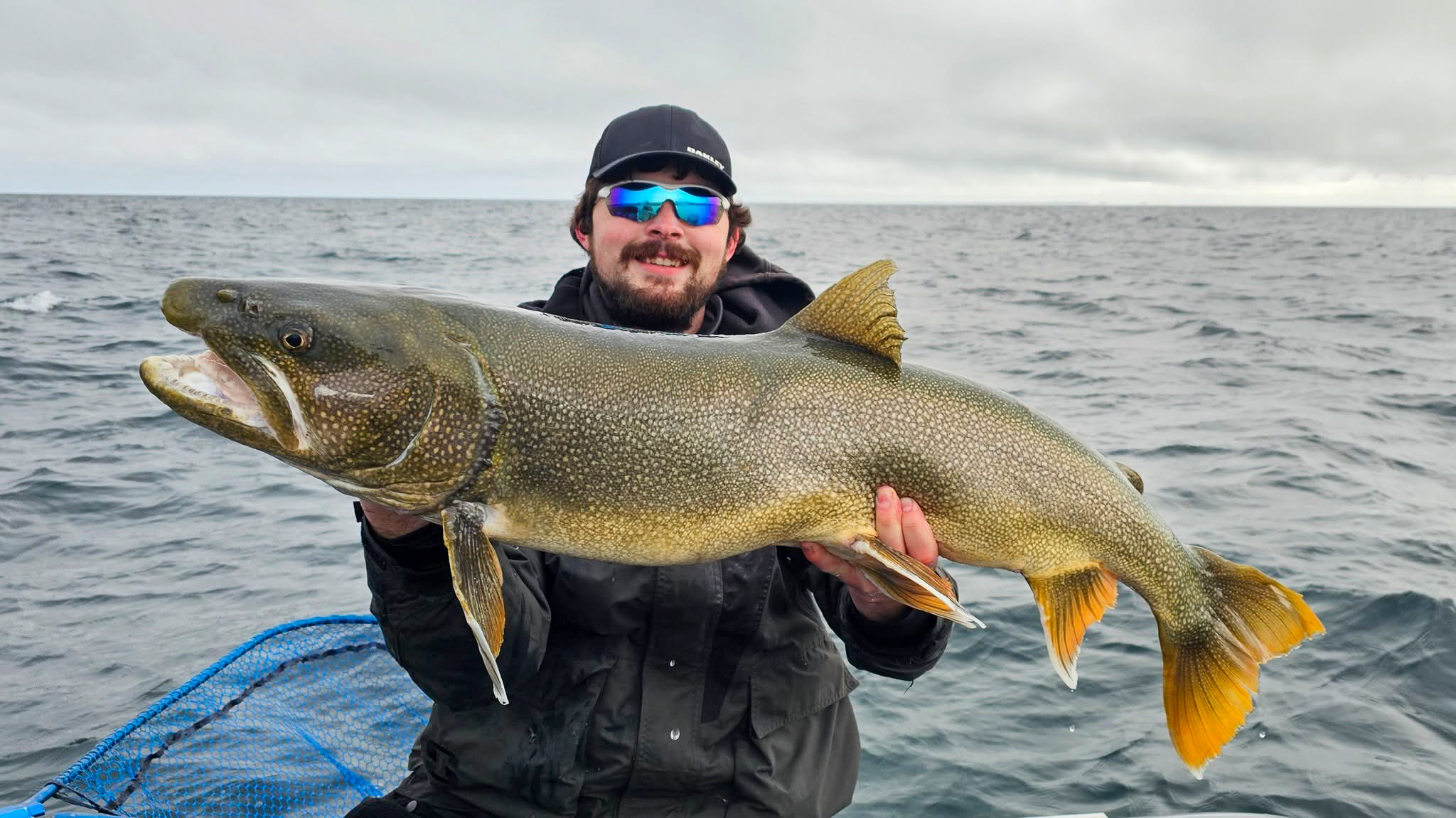 Man holds up a record lake trout in Minnesota