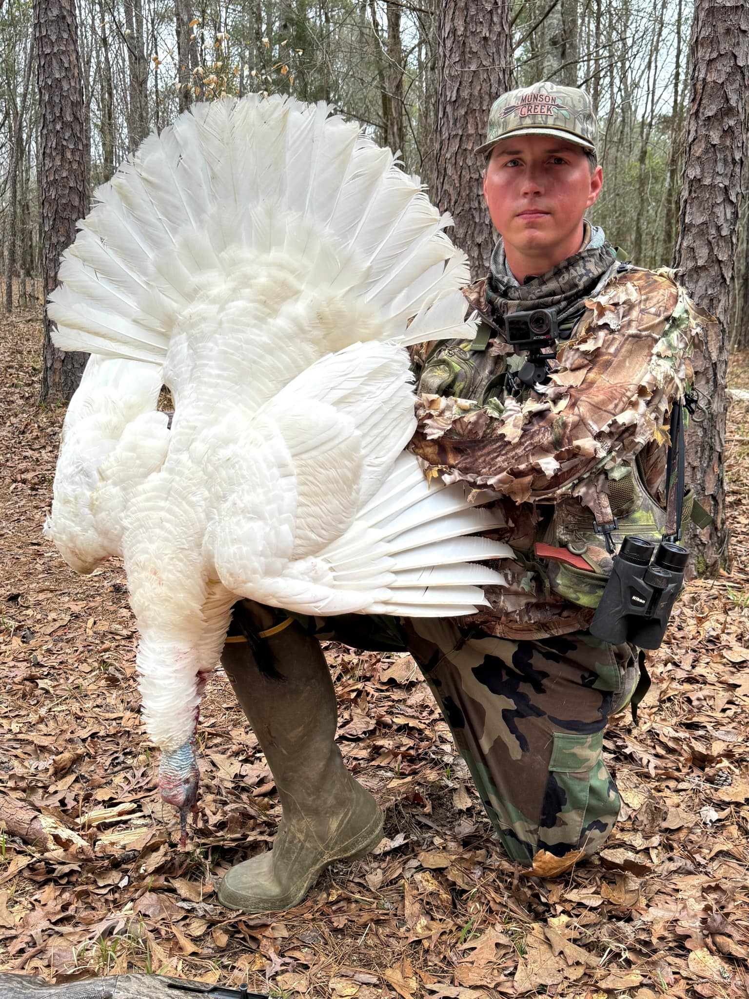 A hunter poses with a white turkey.