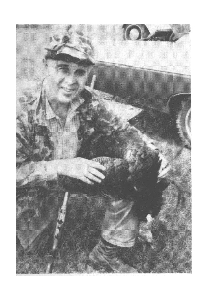 A black and white photo of a man with a double beareded turkey