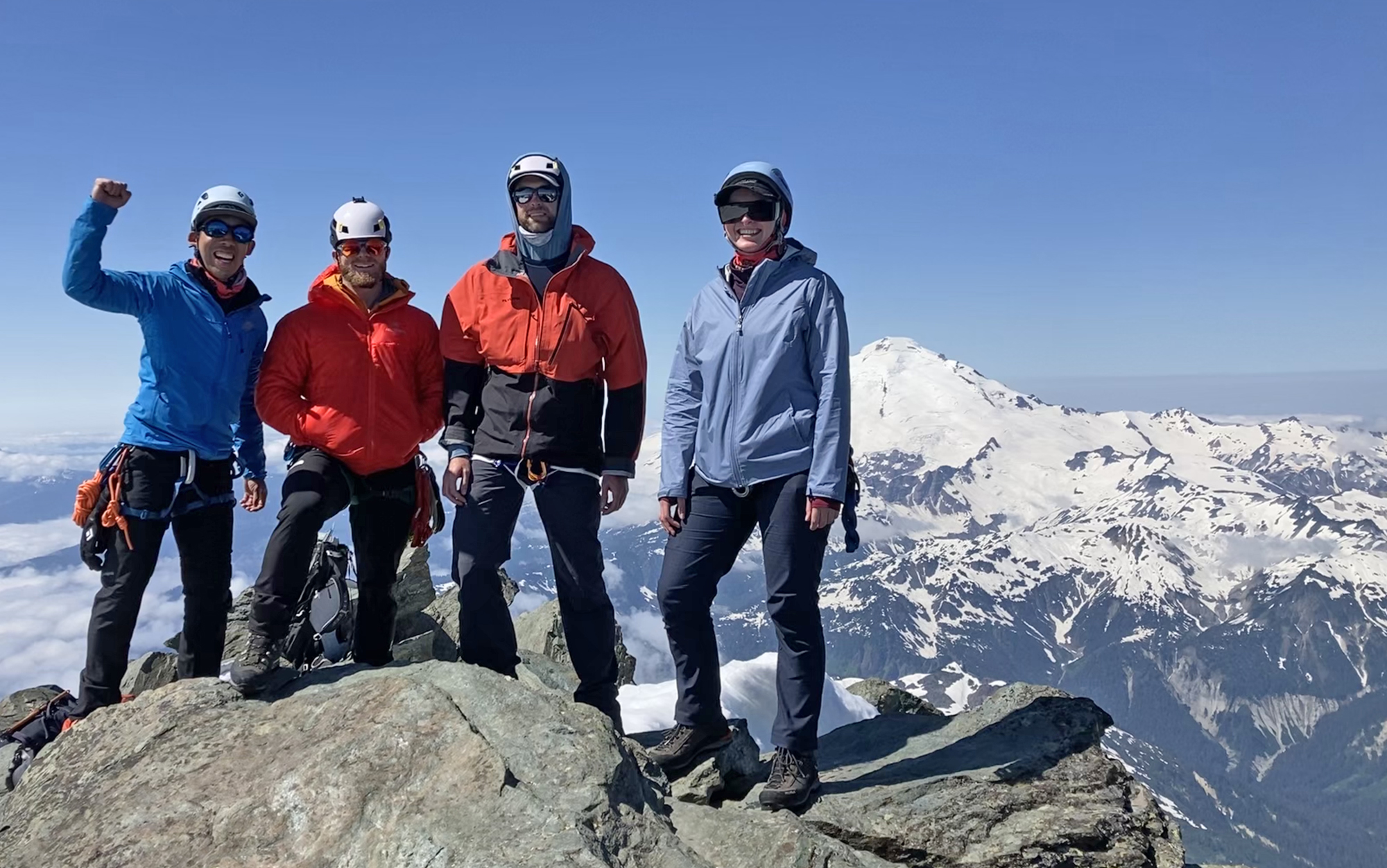 A group of climbers stand on a summit.